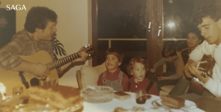 A young Captain Franko watches his father and grandfather play guitar around their family dining table.
